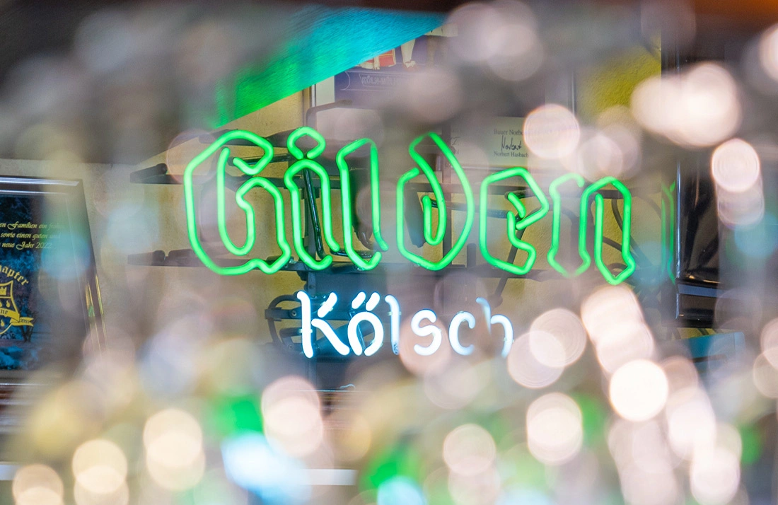 Grünes Neonlicht formt die Worte auf einem unscharfen Hintergrund.